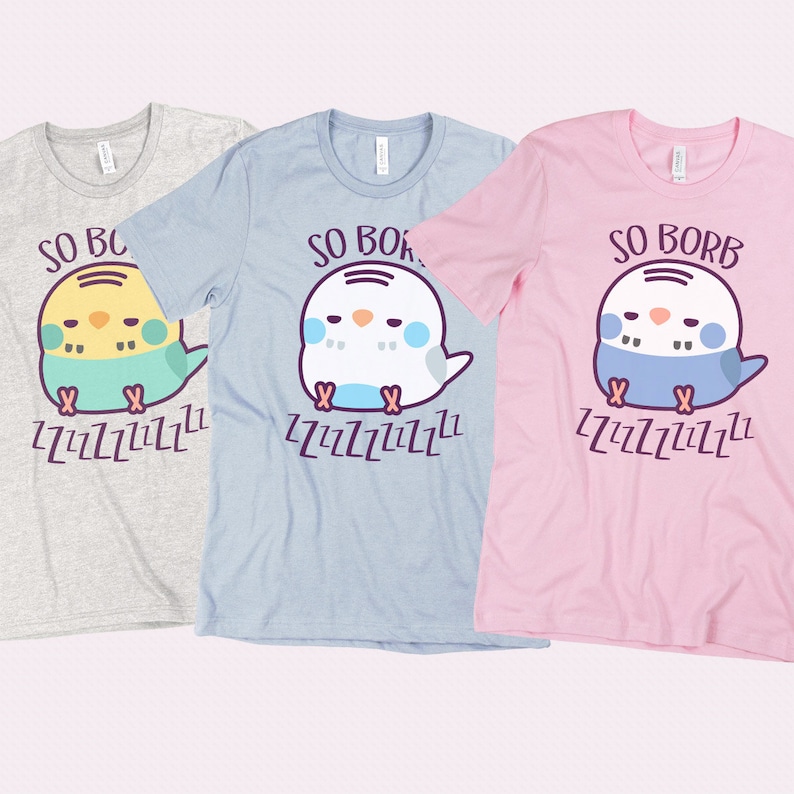 May include: Three t-shirts featuring a cute cartoon bird design. The shirts are in grey, light blue, and pink. The bird is sleeping and the text on the shirts says "So Borb ZZZZZZZZZZZ".