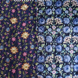 May include: Two fabric swatches with dark blue backgrounds and floral embroidery. The left swatch is labeled "dark embroidered cotton" and the right swatch is labeled "silk".