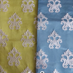 May include: Two fabric swatches with a silver jacquard pattern. The fabric on the left is a light green color and the fabric on the right is a light blue color. The text "silver jacquard" is printed at the top of the image. The numbers "1" and "2" are printed at the bottom of the image.