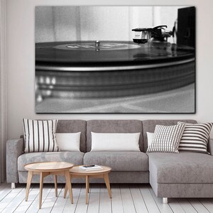 Puede incluir: Una fotograf&iacute;a en blanco y negro de un tocadiscos con un disco girando en el plato. La aguja est&aacute; en el surco del disco.
