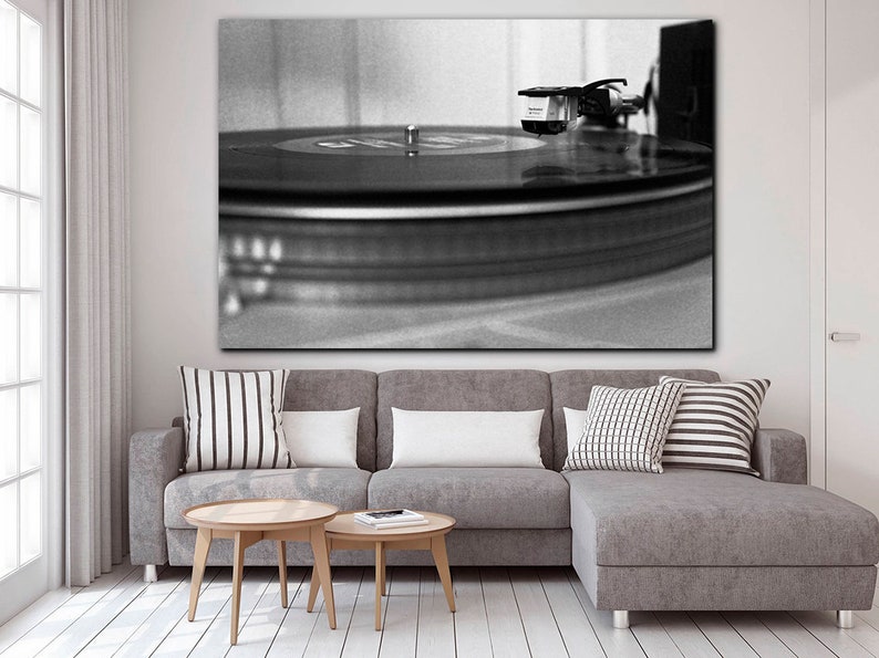 Puede incluir: Una fotograf&iacute;a en blanco y negro de un tocadiscos con un disco girando en el plato. La aguja est&aacute; en el surco del disco.