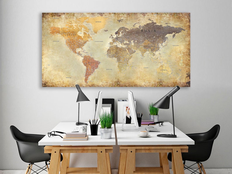 May include: A vintage-style world map print with a distressed, aged look hangs above two white desks with black chairs. Each desk has a black lamp, a computer monitor, and a potted plant.
