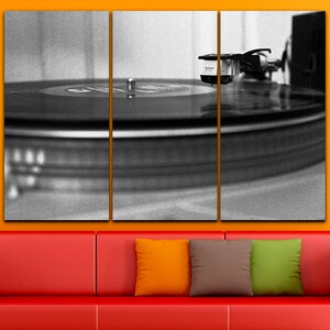 Puede incluir: Primer plano en blanco y negro de un tocadiscos con una aguja en un disco de vinilo. El disco gira en un plato.