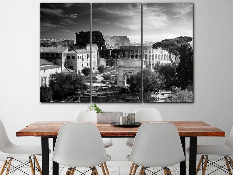 May include: A black and white photo of the Colosseum in Rome, Italy. The photo is split into three panels, showing the Colosseum from different angles. The photo is taken from a high vantage point, and the Colosseum is surrounded by trees and buildings.