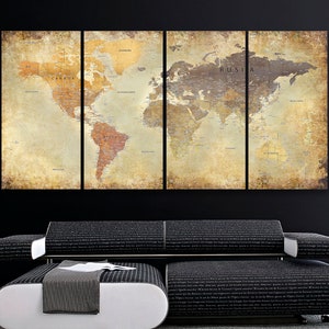 May include: A vintage-style world map print in four panels, featuring a distressed, aged look with a brown and beige color scheme. The map is divided into four sections, each showing a different part of the world. The map is displayed on a black wall above a black couch with a white ottoman.
