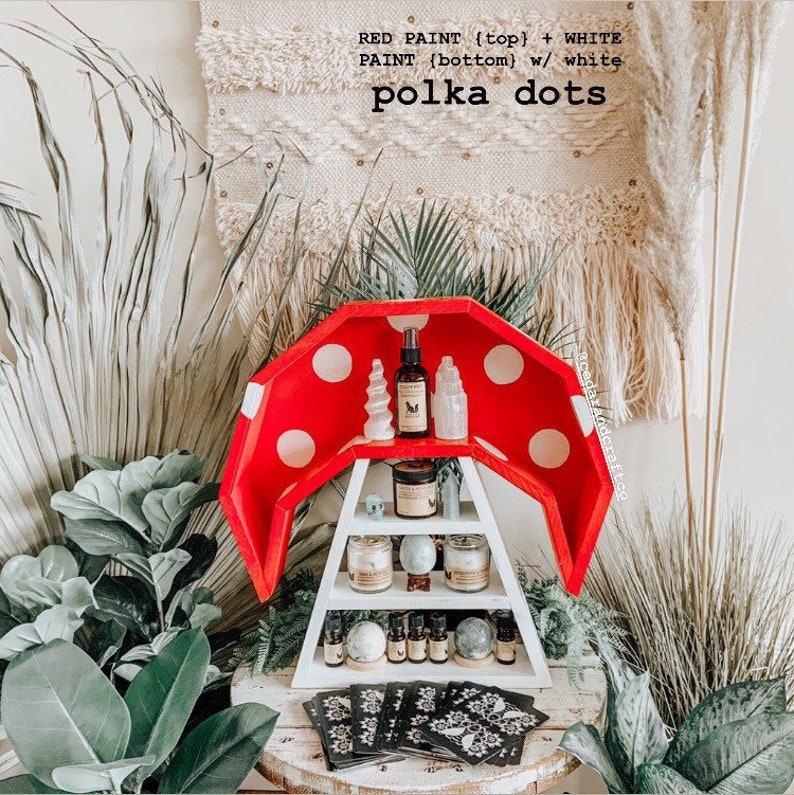 May include: A red and white mushroom-shaped shelf with polka dots, holding various items like candles, essential oils, and crystals. The text on the shelf reads "RED PAINT (top) + WHITE PAINT (bottom) w/ white polka dots".