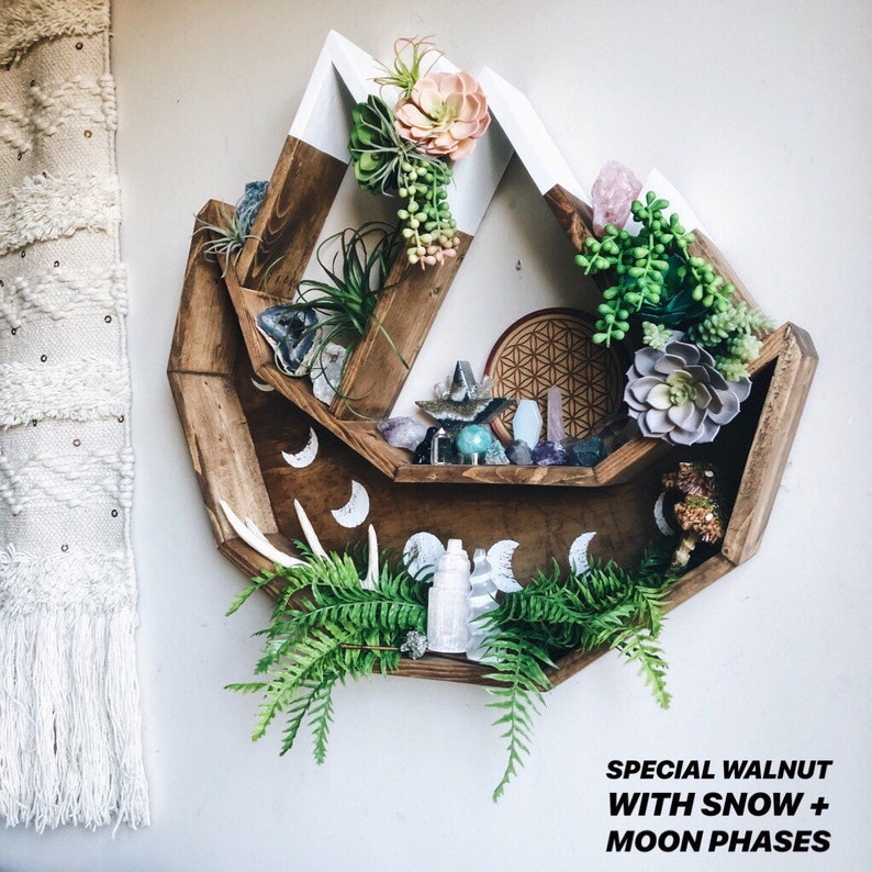 May include: A wooden, geometric wall shelf with a walnut finish and white accents. The shelf is decorated with faux plants, crystals, and moon phase designs. Text on the image reads "SPECIAL WALNUT WITH SNOW + MOON PHASES."
