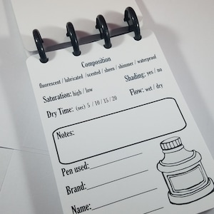 May include: A white page with a black ink pen guide for testing and reviewing ink properties. The guide includes sections for composition, saturation, dry time, shading, flow, notes, pen used, brand, name, and color. There is a black and white illustration of an ink bottle.