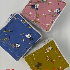 May include: Three square fabric blocks with a white border and a white backing. The blocks are stacked on top of each other. The top block is pink with a white koala bear and floral pattern. The middle block is blue with a white koala bear and floral pattern. The bottom block is green with a brown koala bear and floral pattern. The text #australia and #foundraising is visible in the image.