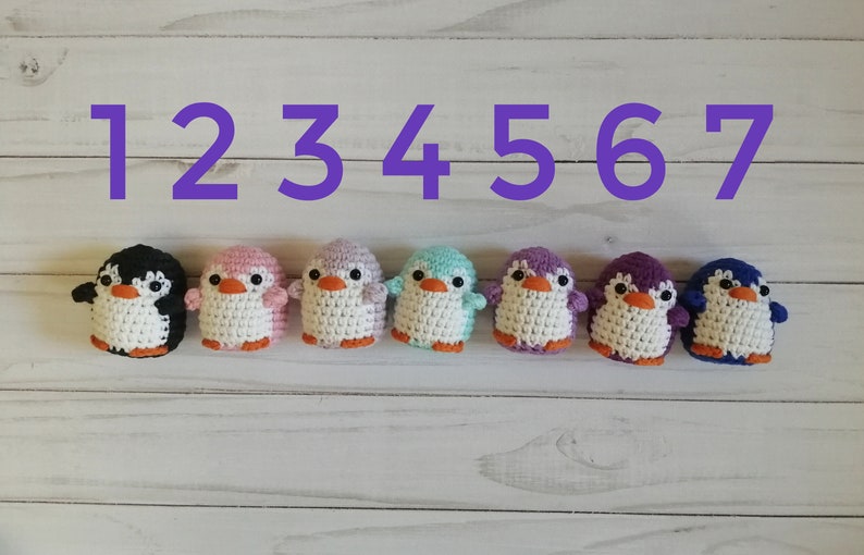 May include: Seven crocheted penguin toys in different colors, numbered 1 through 7. The penguins are black, pink, purple, light blue, lavender, purple, and blue.
