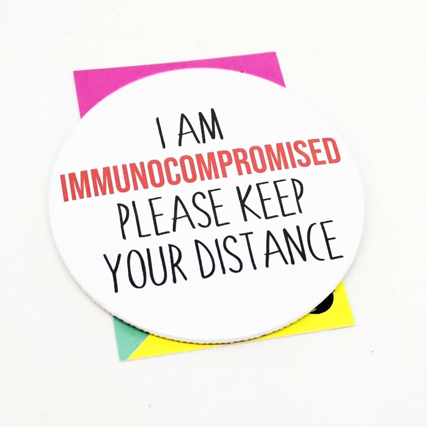 Immunocompromised button bagde. Please keep your distance.