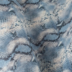 May include: Blue and white snakeskin patterned fabric with a textured surface.