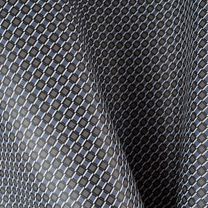 Könnte beinhalten: Nahaufnahme eines Stoffes mit einem geometrischen Muster aus kleinen, dunkelblauen und grauen Quadraten auf weißem Hintergrund. Der Stoff ist zerknittert und hat einen leichten Glanz.