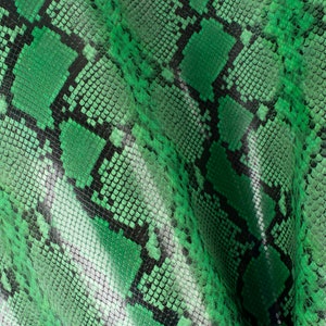 May include: Green snakeskin fabric with a textured pattern. The fabric has a slight sheen and is folded in the centre.