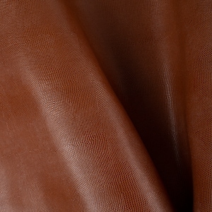 May include: Close-up of a brown leather fabric with a textured, snake-like pattern.