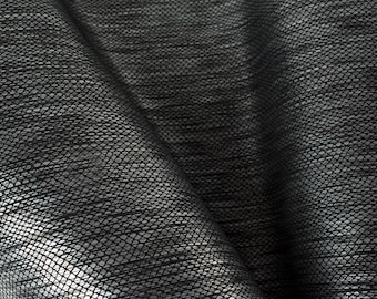 May include: Black woven fabric with a textured, diamond-shaped pattern. The fabric is folded and draped, showing the texture and weave.