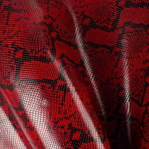 May include: Red faux snakeskin fabric with a textured, scaly pattern.