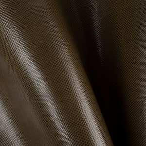 May include: Close-up of a brown textured fabric with a snakeskin pattern.
