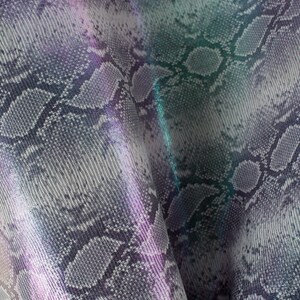 Peut inclure: Gros plan sur un tissu en peau de serpent gris et blanc avec un reflet iridescent. Le tissu a une surface texturée et un motif de motifs d'écailles répétés.