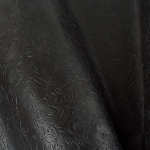 May include: Black embossed fabric with a floral pattern. The fabric has a smooth, shiny surface.