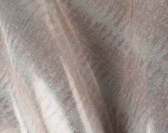 May include: A close-up of a light brown fabric with a subtle, woven pattern. The fabric has a slightly shimmery finish.