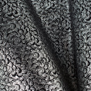 May include: Black fabric with a silver floral pattern. The fabric is folded in half, showing the pattern on both sides.