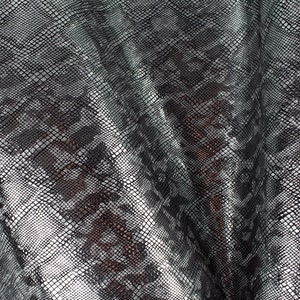 May include: Close-up of a silver and black snakeskin fabric with a textured pattern.
