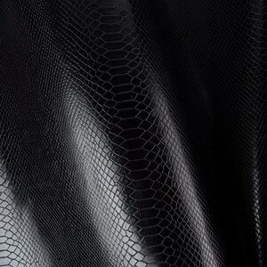 Può includere: Pelle sintetica nera con motivo a pelle di serpente. La pelle è testurizzata e ha una leggera lucentezza.