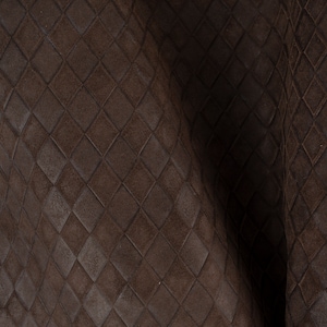 May include: Close-up of a brown leather fabric with a diamond pattern embossed into the surface.