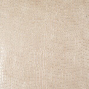 Puede incluir: Primer plano de una tela beige texturizada con un patr&oacute;n de piel de cocodrilo.