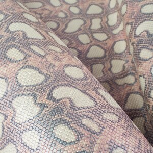 Op de afbeelding: Close-up van een textuurdoek met een slangenhuidpatroon in tinten bruin, beige en grijs.