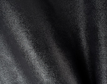 May include: Close-up of black textured leather with a subtle sheen. The leather is folded and shows the texture and grain.
