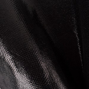 Peut inclure: Cuir noir texturé avec un léger brillant. Le cuir a un motif de peau de serpent.
