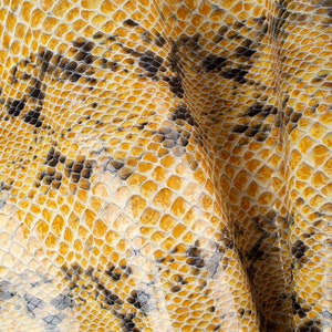 Puede incluir: Primer plano de un patrón de piel de serpiente amarillo y negro. La textura es lisa y brillante, con un ligero brillo.