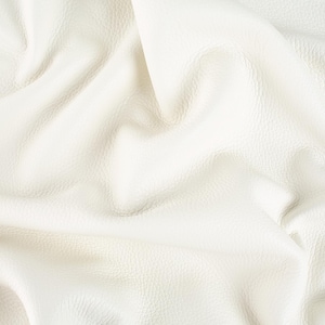 May include: Close-up of a white leather fabric with a textured surface. The fabric is draped, creating soft folds and shadows. The material appears to be supple and smooth, suitable for various crafting projects.