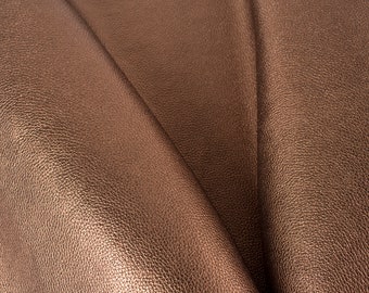 May include: Close-up of a folded piece of brown leather with a textured surface.