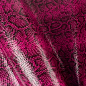 May include: Close-up of a pink and black snakeskin fabric with a textured pattern.