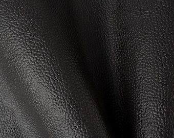 Op de afbeelding: Close-up van zwart, getextureerd leer. Het leer heeft een gegranuleerd oppervlak en een lichte glans.