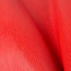 May include: A close-up of a red textured surface with a wood grain pattern.