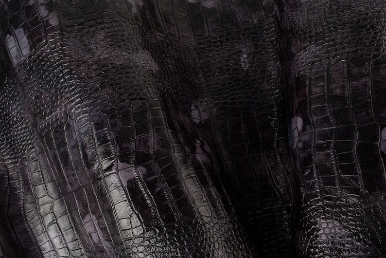 May include: Black crocodile embossed fabric with a subtle iridescent sheen. The fabric has a textured, scaly pattern.