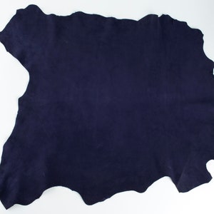 May include: A piece of dark blue suede leather.