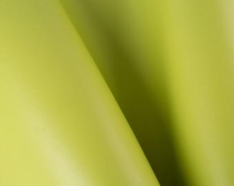 Peut inclure: Gros plan sur un tissu vert lime lisse et texturé. Le tissu est plié en deux, créant une forme douce et incurvée.