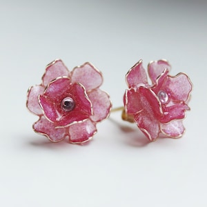 Graziosi orecchini a forma di fiore di peonia realizzati in filo placcato oro e resina UV. Petali semitrasparenti rosa perla che scintillano e trasmettono la luce