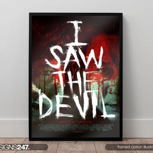 May include: Framed poster with the text "I SAW THE DEVIL" in white, stylized lettering. The background features a blurred image with red and green tones. The poster is in a black frame.