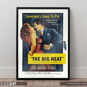 May include: Framed vintage movie poster for "The Big Heat." The poster shows a couple embracing, with text that reads "Somebody's Going To Pay...because he forgot to kill me." The poster has a black frame and is displayed on a white wall.