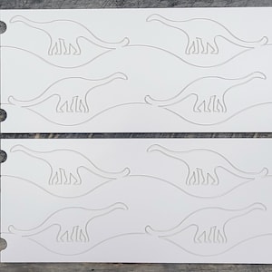 May include: Two white sheets of paper with a dinosaur silhouette cut out on each sheet. The dinosaur is facing right and has a long neck and tail. The sheets are stacked on top of each other.