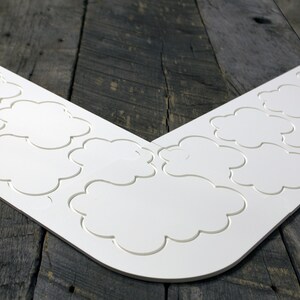 May include: White corner trim with a decorative cloud pattern. The trim is made of a flexible material and can be used to create a unique and stylish look in any room.