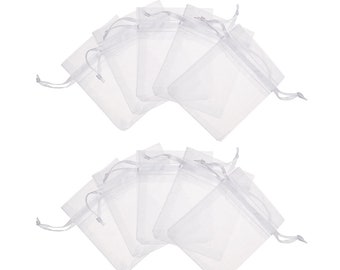 Puede incluir: Un conjunto de 10 bolsas de regalo de organza blanca transparente con cordón de ajuste. Las bolsas están dispuestas en dos filas de cinco, con la fila superior superponiéndose ligeramente a la fila inferior.