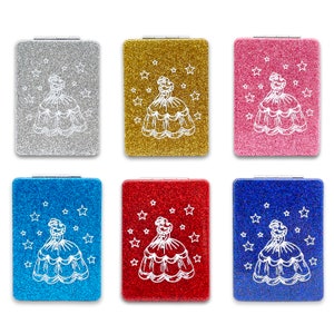 May include: Six glitter compact mirrors in silver, gold, pink, blue, red, and dark blue. Each mirror features a white outline of a dress and stars. The compacts are rectangular with a silver hinge.
