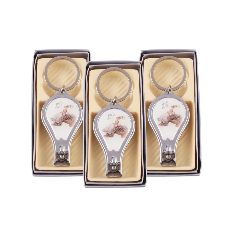 Peut inclure: Trois porte-cl&eacute;s argent&eacute;s avec coupe-ongles et un motif de b&eacute;b&eacute;. Chaque porte-cl&eacute;s a un fond blanc avec un b&eacute;b&eacute; en robe blanche et un motif floral. Les porte-cl&eacute;s sont dans des bo&icirc;tes individuelles avec un fond brun clair.